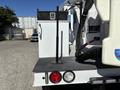 A 2016 Ford F-550 utility truck with a flatbed featuring a mounted pole and storage compartment on the side