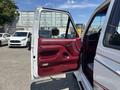 1995 Ford F-250 with an open driver side door featuring red interior and controls visible inside the cab