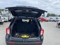 A 2021 Ford Explorer with its rear hatch opened displaying the cargo area and a spare tire on the floor