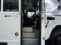A 2022 Blue Bird BB Conventional school bus showing the entrance steps and driver’s seat area with safety signage visible