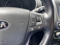 Close-up of the steering wheel of a 2015 Kia Sorento featuring controls for cruise and audio settings