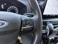 Image shows the steering wheel of a 2022 Ford Transit with controls for navigation and audio functions visible on the wheel
