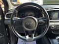 Steering wheel of a 2017 Kia Sorento with control buttons and the Kia logo prominently displayed in the center
