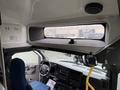 Interior of a 2013 Chevrolet Express with a dashboard featuring controls and a blue driver's seat visible