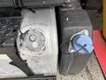 Close-up of a 2015 Freightliner M2 106 fuel tank showing the fuel cap and a blue DEF cap with a tether