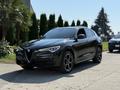 A 2020 Alfa Romeo Stelvio in black with distinctive front grille and sleek design showcasing sporty wheels and a modern SUV silhouette