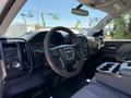 Interior of a 2016 GMC Sierra 1500 featuring a steering wheel dashboard and center console with cup holders