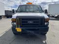 A white 2009 Ford Econoline van with a yellow safety light on the roof and a yellow boot on the front wheel