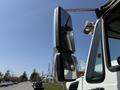 A 2009 International 7500 truck with a prominent side mirror reflecting its surroundings