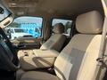 Interior of a 2014 Ford F-350 SD showing two tan fabric seats with an armrest in between and a spacious cabin design