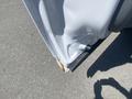 Close-up of the lower edge of a white 2016 Ford F-350 SD showing noticeable rust and damage to the metal surface