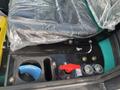 A close-up of the control panel of a 2024 AGT Industrial Green QH13R Mini Excavator featuring a seat covered in plastic and various switches and knobs