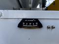 A close-up of a level gauge indicating measurement from 0 to 10 with a black frame and white markings on a white surface