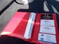 A red folder containing business cards and a document labeled Hino, associated with a 2015 Hino 195 truck