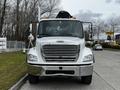 A 2006 Freightliner M2 112 truck with a silver body and chrome grille facing directly towards the viewer