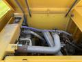 Close-up of the engine compartment of a 2022 TerraMac Tracked Dump showing various pipes and components arranged in yellow casing