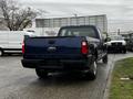 A blue 2008 Ford F-250 Super Duty truck parked with its rear facing the viewer