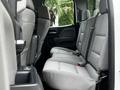 Interior view of the backseat area of a 2018 GMC Sierra 1500 with gray fabric seats and seat belts visible