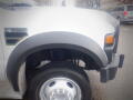 A 2008 Ford F-550 showing the front fender wheel and tire with visible logo and body structure