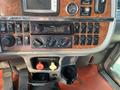 Dashboard of a 2009 Peterbilt Highway featuring a Kenwood radio multiple switches knobs and a drink holder