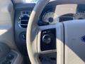 Dashboard view of a 2013 Ford Expedition showing the steering wheel and control buttons for cruise control and headlights