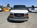 A white 2016 GMC Savana van viewed from the front with a black grille and orange accents on the lower bumper