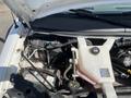 A 2013 Chevrolet Express with its hood open showcasing the engine compartment including battery and fluid reservoir
