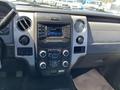 Interior dashboard of a 2014 Ford F-150 featuring a radio display and various control buttons and knobs