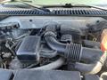 A 2013 Ford Expedition engine compartment showing various components including the air intake and hoses