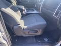 Interior view of a 2021 RAM 1500 showing the driver's seat with fabric upholstery and a central console featuring storage compartments and cup holders