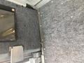 Image shows the interior of a 2012 Ford Econoline with gray felt lining and metal trim elements