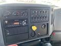 Dashboard of a 2007 International 7300 featuring gauges controls a radio and various switches along with a keychain attached to the ignition area