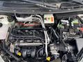 Engine compartment of a 2013 Ford Transit Connect showing the engine assembly various components and wiring harness