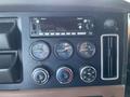 The dashboard of a 2022 Freightliner Cascadia featuring a radio display and various gauges for air pressure and temperature control knobs