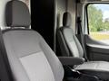 Two grey fabric seats in the cab of a 2022 Ford Transit with a simple design and armrests