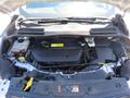 Engine compartment of a 2015 Ford Escape showing the engine block radiator and various components including hoses and fluid reservoirs