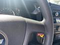 Close-up of a black steering wheel with the Chevrolet logo visible and controls for audio and cruise settings on the left side