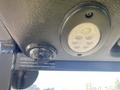 Close-up of a Kubota F3680 dashboard featuring a round black light fixture and a round camera lens mounted on a textured black surface