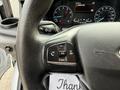 Close-up of a steering wheel from a 2022 Ford Transit featuring control buttons for volume and voice commands