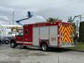 A red 2007 Ford F-550 fire rescue truck with reflective markings and a utility box on the back parked on a paved surface