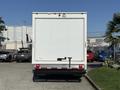 A white 2024 Chevrolet Express cargo van viewed from the rear with a plain back door and a tow hitch attached at the bottom