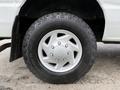 A close-up of a silver wheel with five spokes on a 2008 Ford Econoline featuring a rugged tire design and visible tread pattern