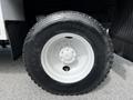 Close-up of a black tire mounted on a white wheel of a 2012 Freightliner M2 106 truck with visible tread patterns and a valve stem
