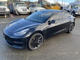 A black 2019 Tesla Model 3 with a sleek design and distinct wheel rims is displayed at an angle highlighting its sporty appearance