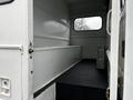 Interior of a 2007 Freightliner M2 106 with bare metal walls and a textured black floor featuring a step at the entrance and a metallic vent on the side