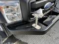 A 2011 Ford F-450 SD truck with a visible front bumper and headlight structure featuring a mounted bracket on the front for accessory attachment
