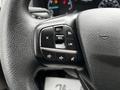 Steering wheel controls of a 2023 Ford Transit including buttons for setting cruise control and audio adjustments