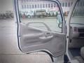 The interior door of a 2003 Toyota Toyoace showing a beige panel with a door handle and speaker area