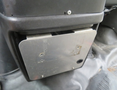 Metal storage compartment with a flat surface and exposed screws located in the front interior of a 2020 Chevrolet Express