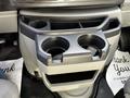 A gray cup holder with two circular openings and a storage compartment, designed for a 2019 Ford Econoline